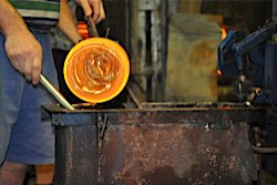 Glassblowing and handcrafting an Alladin from hot glass in the foundry